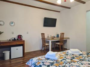 a bedroom with a bed and a table with chairs at Luca's House ( aeroport Henry Coanda, Therme Bucuresti) in Baloteşti