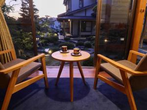 a table and two chairs with two cups on it at WABISABI ISURUGI KASHIWAYA - Vacation STAY 34839v in Oyabe