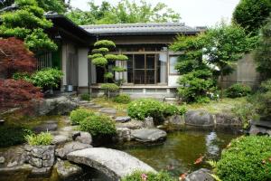a garden with a pond in front of a house at WABISABI ISURUGI KASHIWAYA - Vacation STAY 34839v in Oyabe