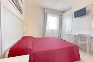 een rood bed in een witte kamer met een raam bij HOTEL PIGALLE in Forte dei Marmi