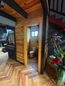 een badkamer met een toilet in een kamer met houten vloeren bij Cabaña Bagheera in Mazamitla