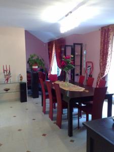 een eetkamer met een tafel en rode stoelen bij Villa Cendrillon in Magny-le-Hongre