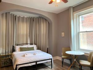 a bedroom with a bed and a table and a window at Alina & Fanny - Philadelphia S Broad St in Philadelphia