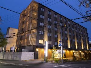 un bâtiment situé dans une rue de la ville la nuit dans l'établissement Ariston Hotel Kyoto Jujo, à Kyoto