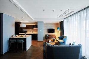 a room with a kitchen and a living room at Felix by STX Hotel & Suite in Busan