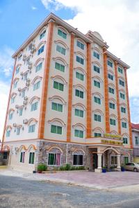 - un grand bâtiment avec des tons orange et blanc dans l'établissement Golden Star Inn, à Sihanoukville