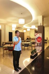 a woman standing in a lobby with her arms crossed at Cordela Inn HM Yamin Medan in Medan +26 photos