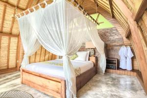 a bedroom with a bed with a mosquito net at Romantic Barn with Mt. Agung Views in Sidemen