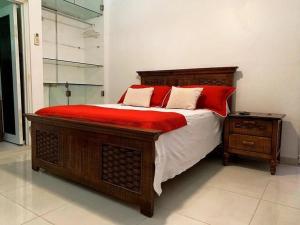 ein Schlafzimmer mit einem großen Bett mit roten Kissen in der Unterkunft Room in Condo - Malecon Premium Rooms in Santo Domingo