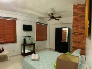 uma sala de estar com uma ventoinha de tecto e um sofá em Room in Condo - Malecon Premium Rooms em Santo Domingo