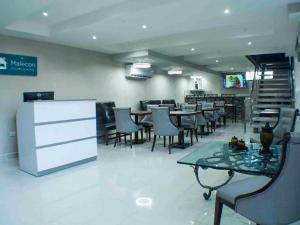 ein Esszimmer mit Tischen und Stühlen in einem Restaurant in der Unterkunft Malecon Cozy - Premium Plus 11 in Santo Domingo