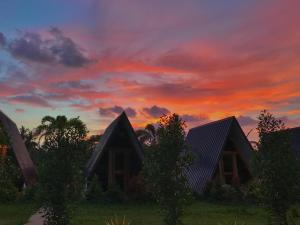 a sunset over the roofs of cottages at Hardin De Marbella in El Nido