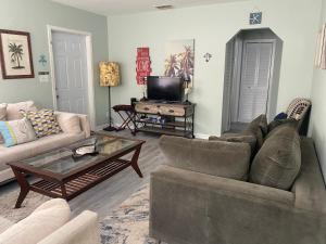 a living room with a couch and a coffee table at 5 min to Beaches! Biz Ready Large Living Room Fenced Backyard Patio Grill Firepit Driveway Parking in Lake Worth