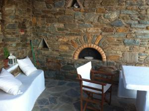 a room with a stone wall with a bed and a chair at Aegean living Villa in Agios Romanos +89 photos