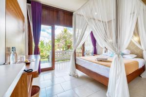 Schlafzimmer mit einem Bett mit Moskitonetz in der Unterkunft Ubud Sari Health Resort in Ubud
