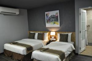 a hotel room with two beds in a room at Valya Hotel, Kuala Terengganu in Kuala Terengganu
