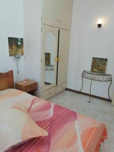 a bedroom with a bed with a pink blanket at Roommate for rent in flic en flac in Rivière Noire