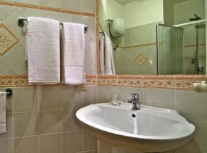 y baño con lavabo, espejo y toallas. en Le Stanze Di Nico, en Roma