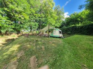 un camping con una tienda en medio de un campo en Koppány Pines Rewild Escapes - Vintage Caravan, en Koppányszántó