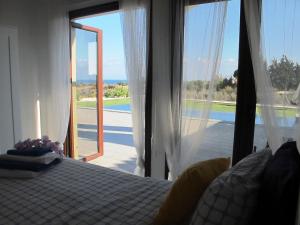 a bedroom with a bed and a large glass door at Villa Olivo Maroni in Maroni