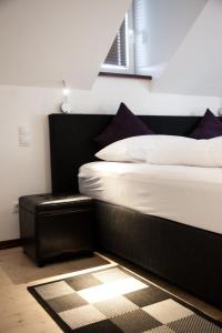 een slaapkamer met een bed met een zwart hoofdeinde bij P&G Rooms in Höhr-Grenzhausen