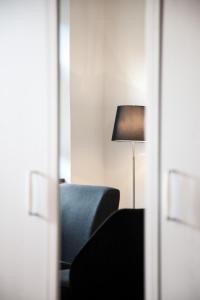 een kamer met een blauwe stoel en een lamp bij P&G Rooms in Höhr-Grenzhausen