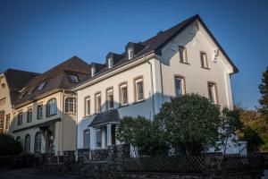 une grande maison blanche avec un toit noir dans l'établissement P&G Rooms, à Höhr-Grenzhausen