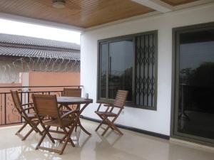 eine Terrasse mit Tisch und Stühlen auf einem Balkon in der Unterkunft Ghouse - Ideal For Friends family And Corporate in Lateman