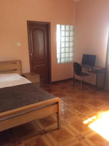 ein Schlafzimmer mit einem Bett und einem Schreibtisch mit einem Laptop in der Unterkunft Ghouse - Ideal For Friends family And Corporate in Lateman