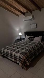 a bedroom with a bed with a plaid blanket at Oak Villa Montego Bay 2 in Montego Bay