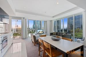 Una cocina y una sala de estar con mesa y sillas. en Gold Coast Private Apartments - H Residences, Surfers Paradise, en Gold Coast