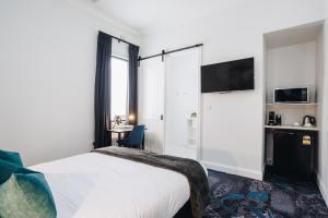 a hotel room with a bed and a desk at Royal Hotel Wyong in Wyong