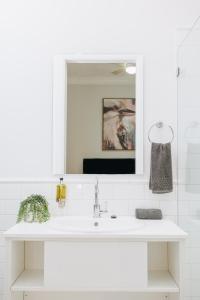 a white bathroom with a sink and a mirror at Royal Hotel Wyong in Wyong