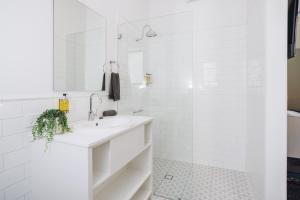 a white bathroom with a sink and a mirror at Royal Hotel Wyong in Wyong