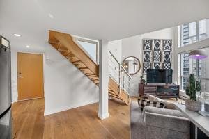 Habitación con escalera y sala de estar con sofá. en Rare Find Loft with full kitchen at Heart of Downtown, en Vancouver