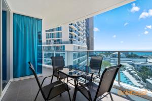 d'une salle à manger avec une table en verre et des chaises sur un balcon. dans l'établissement Gold Coast Private Apartments - H Residences, Surfers Paradise, à Gold Coast