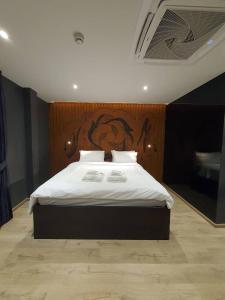 a bedroom with a large bed with a wooden headboard at The Nhorm Hotel Ratchada in Bangkok