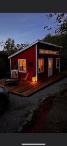 a red tiny house with a wooden deck at McMillan Ranch Yosemite in Coarsegold