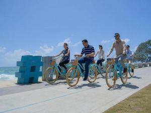 a group of people riding bikes down a sidewalk at Room in Condo - Malecon Cozy Private Room 6 in Santo Domingo