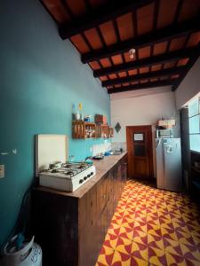a kitchen with a stove and a refrigerator at Amura Hostal in Antigua Guatemala