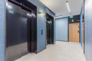 una fila di ascensori in un corridoio con una porta di Apartament Port a Gdynia