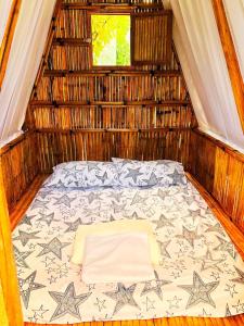 Zimmer mit einem Bett in einem Strohhaus in der Unterkunft Jodels Paradise in Ligao