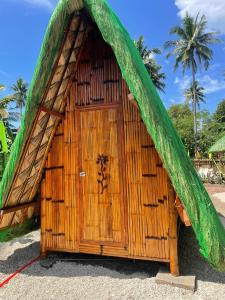 eine kleine Holzhütte mit grünem Dach in der Unterkunft Jodels Paradise in Ligao