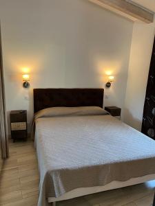 a bedroom with a bed with two lights on the wall at Pleasant private villa Located in a garden of 8000m2 with trees in Porto-Vecchio +13 photos
