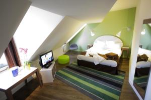 a attic room with two beds and a television at Mercure Strasbourg Centre Gare in Strasbourg