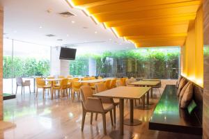 a restaurant with tables and chairs and a large window at Tango Vibrant Living Hotel - SHA Extra Plus in Bangkok