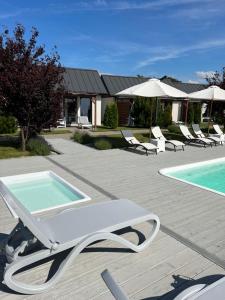 une terrasse avec des chaises et une piscine dans l'établissement Słoneczny Zakątek, à Strzeżewo