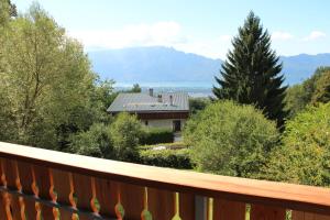 a balcony with a view of a house with trees at Holiday home Maison de la litiére in Pugny-Chatenod