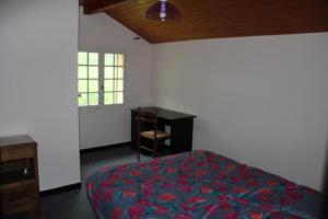 a bedroom with a bed and a desk at Holiday home Maison de la litiére in Pugny-Chatenod