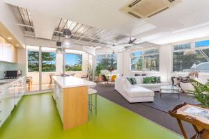 an open kitchen and living room with green floors at The Ritz in Yamba
